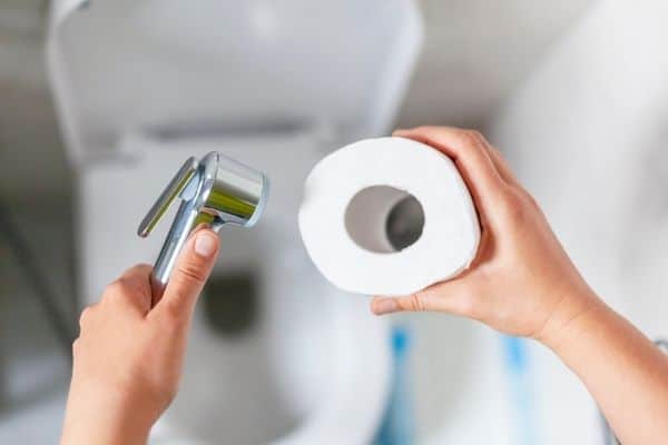 Person holding bidet and tissue