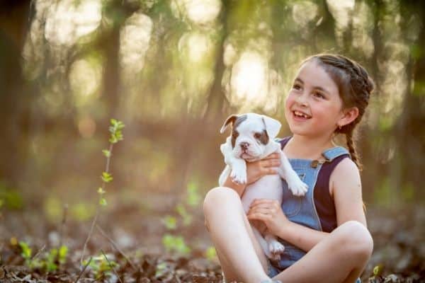 Happy kid holding a puppy