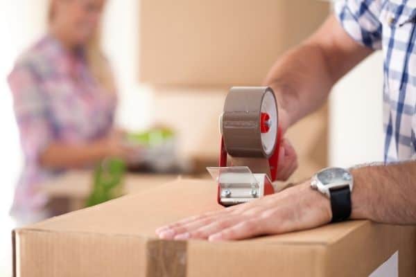 Couple packing stuff in moving boxes