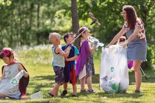 Mom and children learning how to be eco-friendly by cleaning outdoors