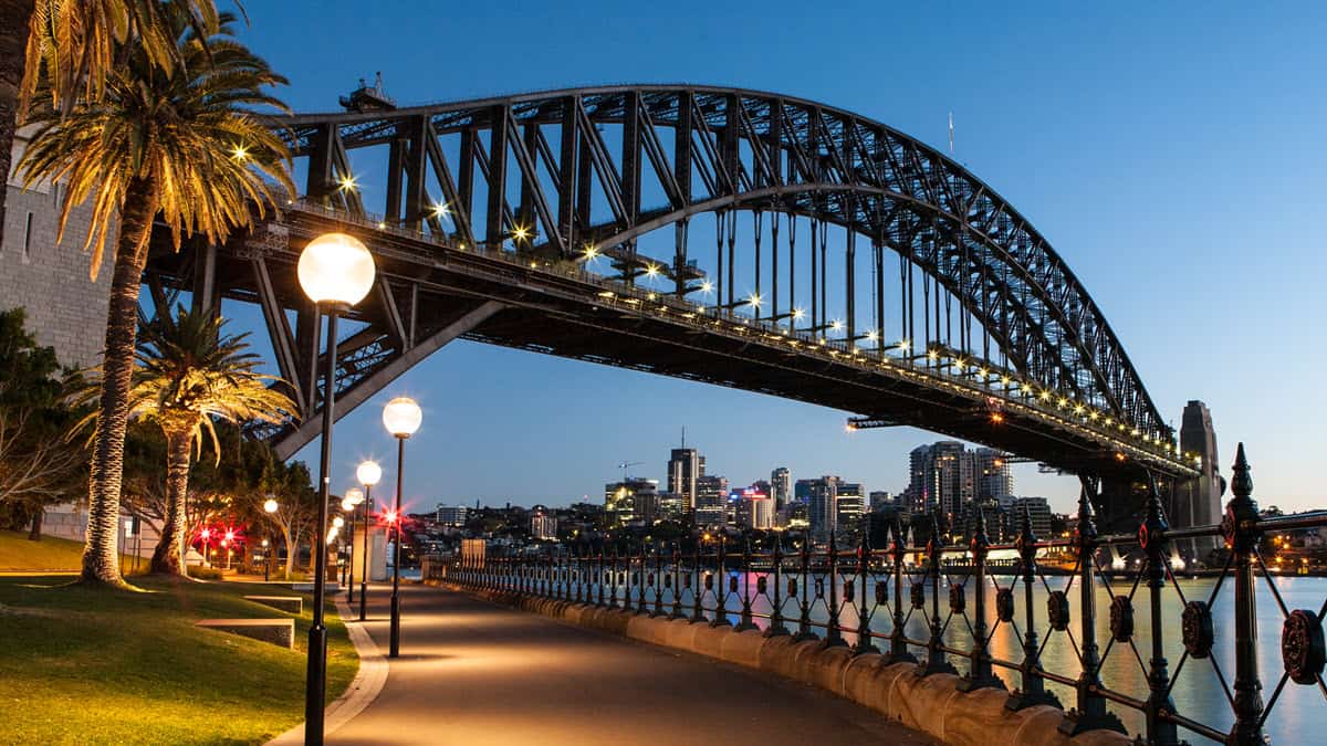 Sydney Harbour Bridge at night from lit walking path