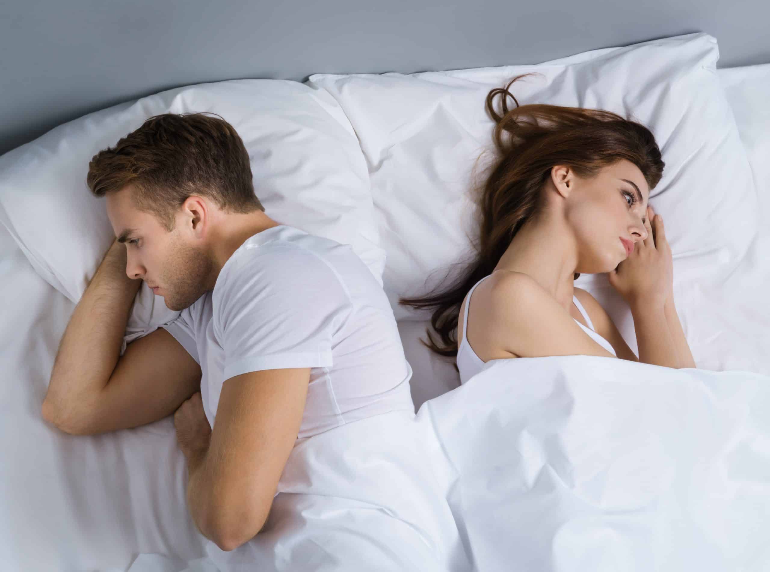 Unhappy young couple in bedroom