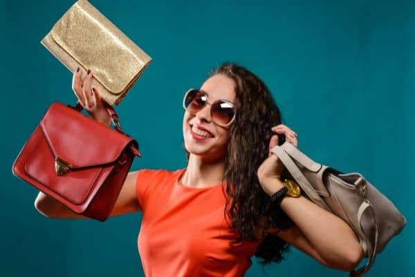 happy woman holding different fashion bags