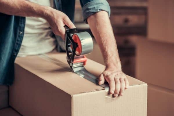 person taping up moving box