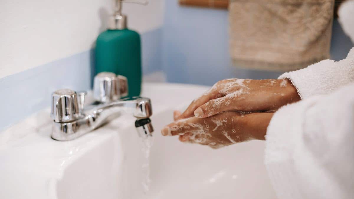 Woman washing hands at bathroom sink