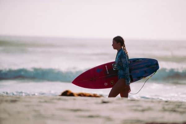 surfer woman waling on the beach