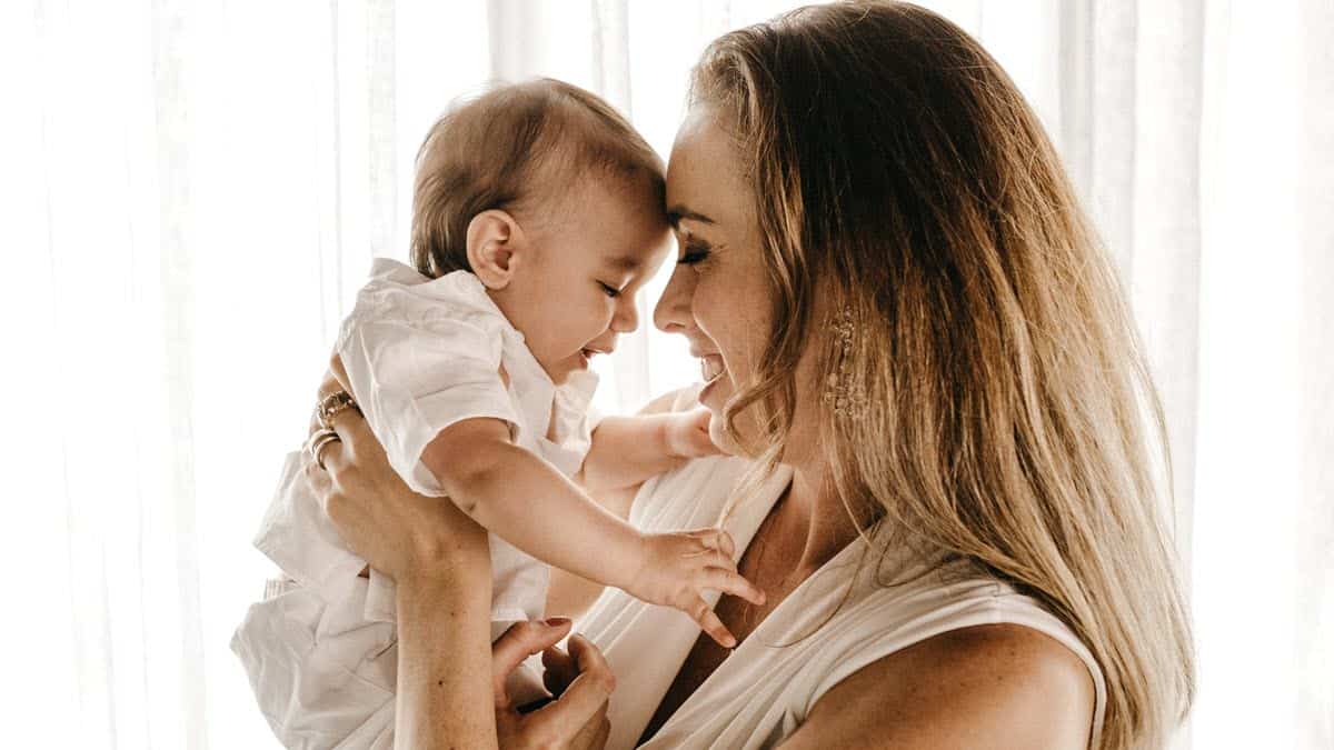 Mother holding baby head to head and smiling