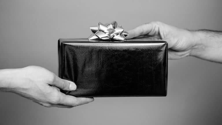 Two hands exchanging gift - black and white
