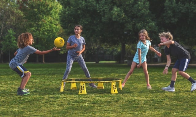 kids playing with ball and trampouline in the backyard