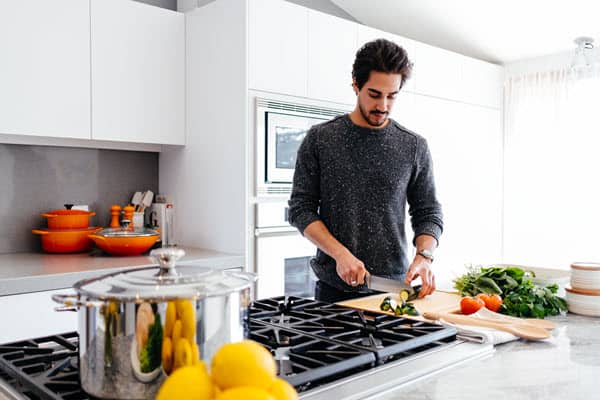 Dark haired man cooking in a kitchen