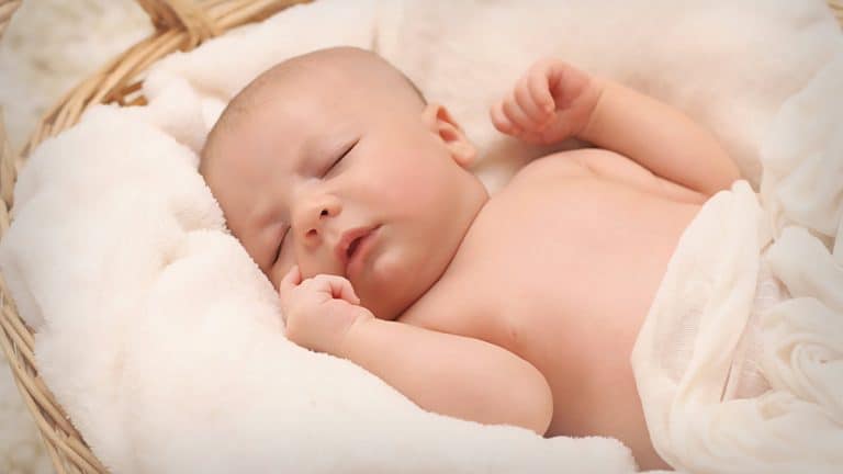 Newborn baby sleeping in bassinet