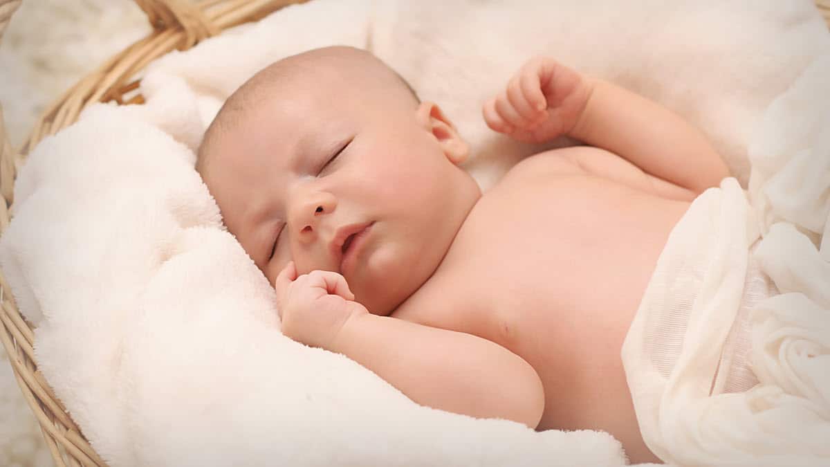 Newborn baby sleeping in bassinet