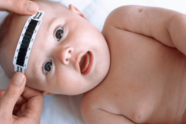 Using a strip forehead thermometer on baby