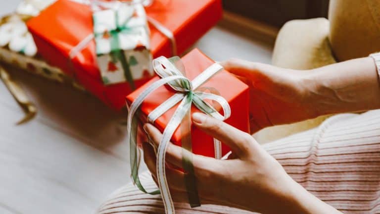 Woman holding red wrapped Christmas gift in hands