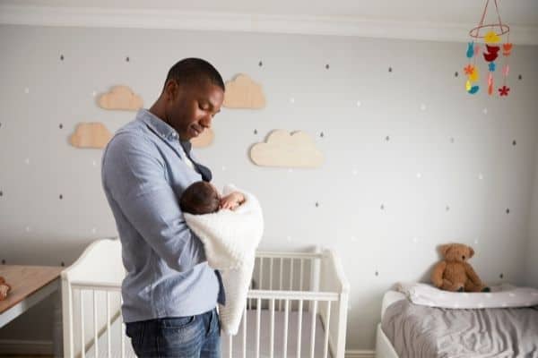 dad with baby in nursery room