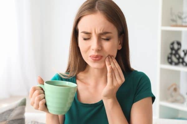 woman gargling salt water to relieve toothache