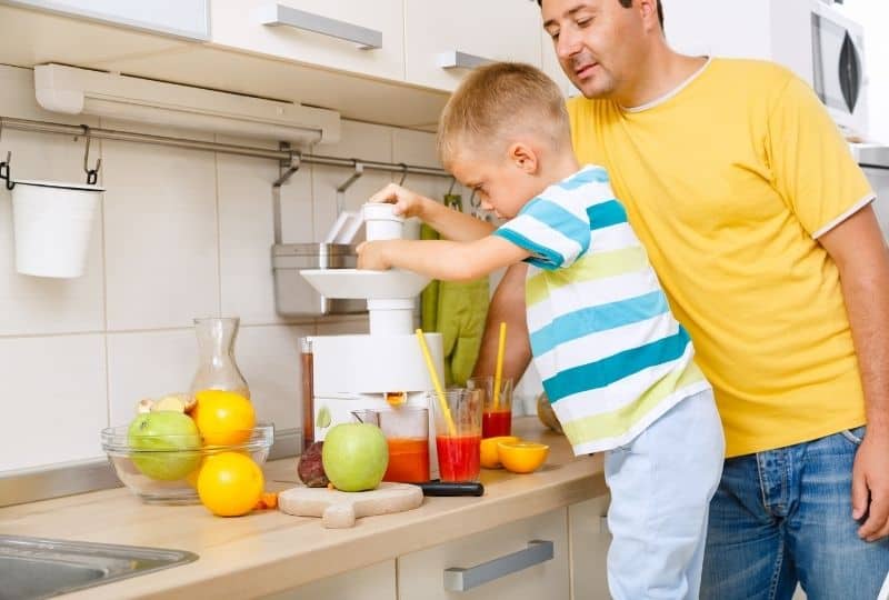Father and son using a cold press juicer australia