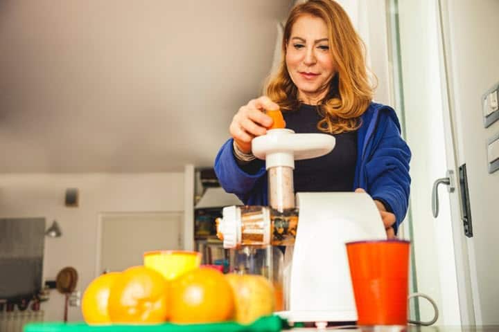 Woman using a masticating juicer