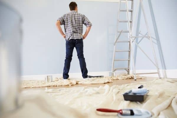 husband decorating baby nursery
