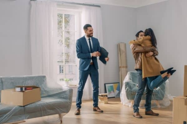 happy couple with real estate agent selling home