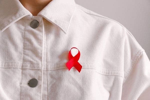 person wearing red ribbon hiv