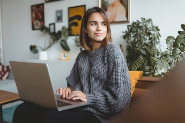 Woman Thinking While Holding Laptop
