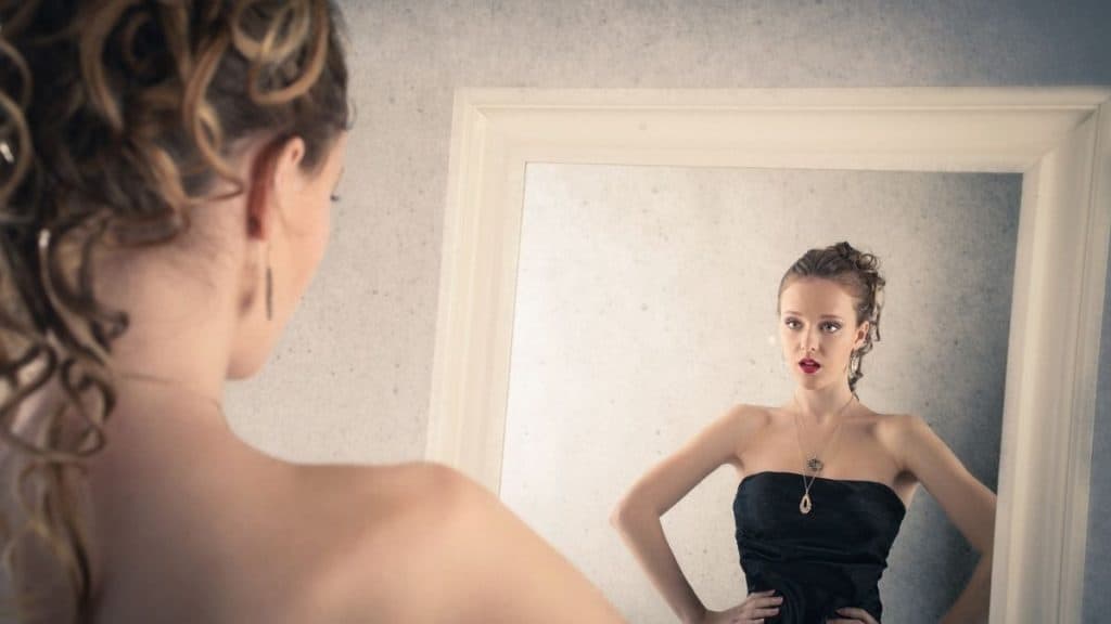 Woman With Gold Statement Earrings And Black Dress