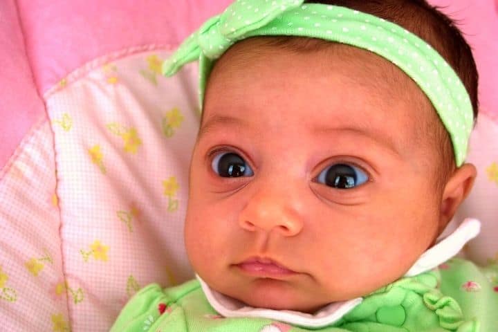 Baby Lying On The Bed With A Pink Sheet