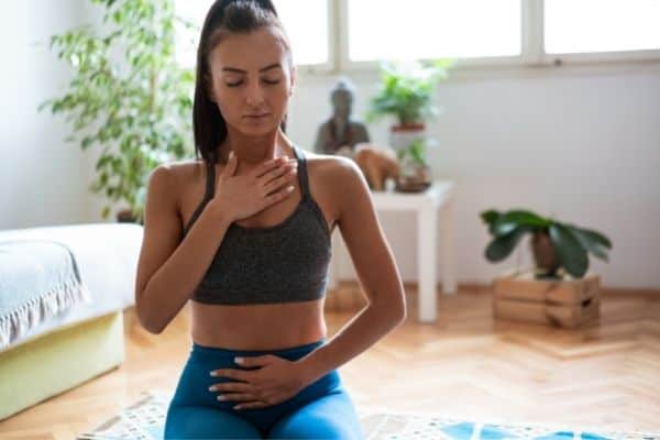 Woman Practicing Diaphragmatic Breathing At Home