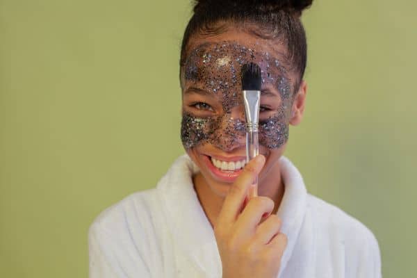 Smiling Woman Exfoliating Face With Facial Mask