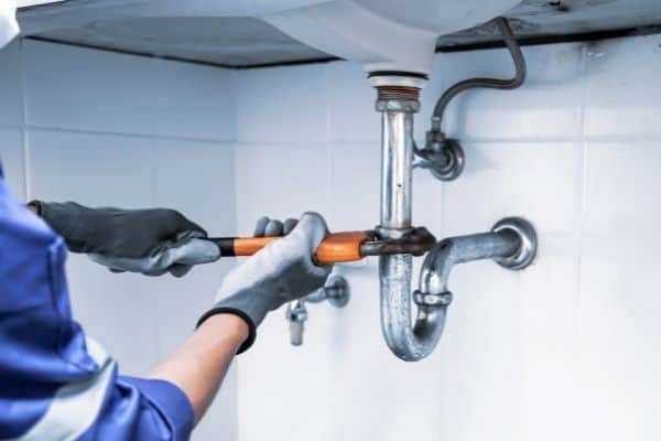 Technician Plumber Fixing Water Pipe
