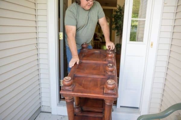Man Moving Heavy Furniture Out Of Home
