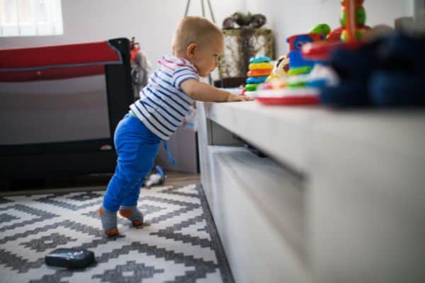 Baby Leaning On Cabinet