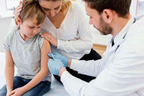 Mother Supporting Child While Getting Vaccinated