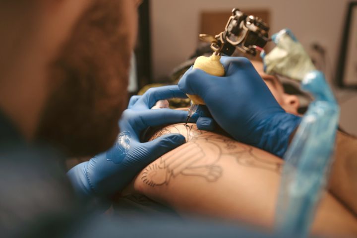 Man Gives A Woman A Tattoo