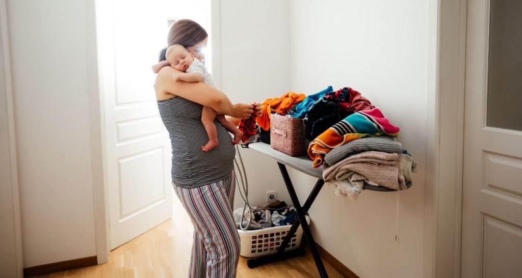 Busy Mum Cleaning While Carrying Baby