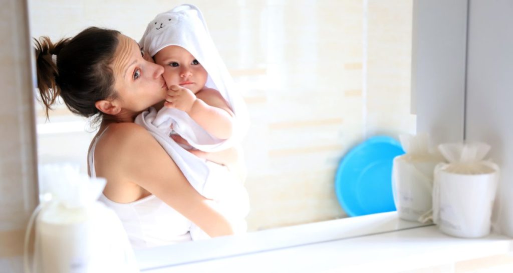mum and baby looking at bathroom mirror